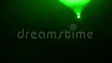 从顶部到顶部烟雾机烟雾中带有轮廓聚光灯的绿色光束的场景照明